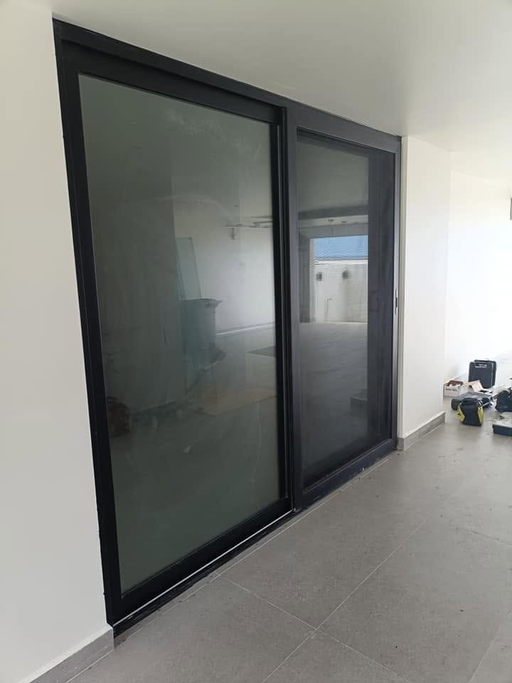 Ventanal corredizo de aluminio negro residencial - Vidriera Monza Mexicali